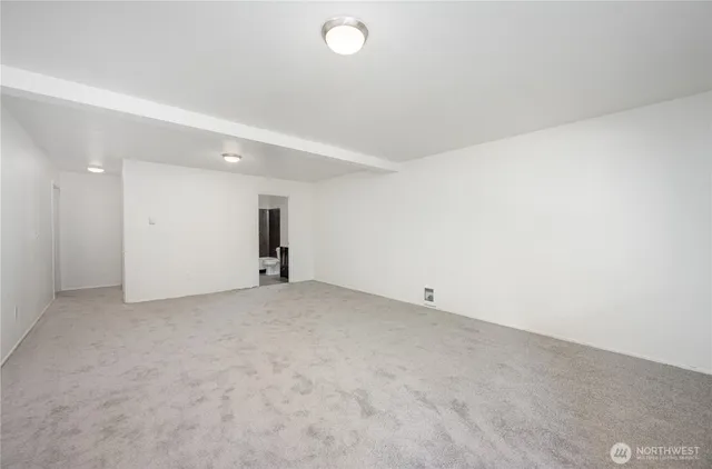 an empty room with an entryway and fan