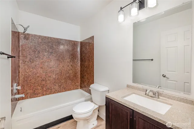 a bathroom with a granite countertop sink toilet and shower
