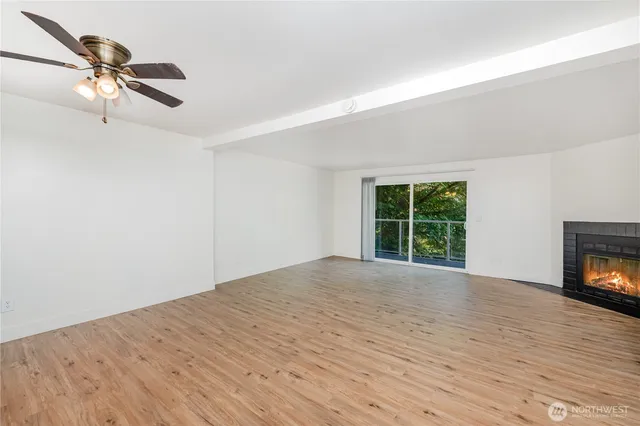 a view of an empty room with a window and fireplace