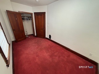 445 Church Street, Unit 2 Wallingford, CT 06492 - Photo 11 of 15 an empty room with closet and mirror
