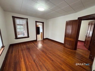 445 Church Street, Unit 2 Wallingford, CT 06492 - Photo 2 of 15 a view of an empty room with wooden floor and a window