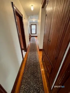 a view of a hallway with wooden floor and stairs