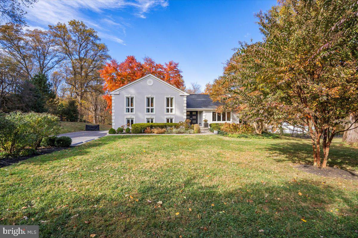 10801 Spring Knoll Drive Potomac, MD 20854 - Photo 3 of 100 a front view of a house with a garden and trees