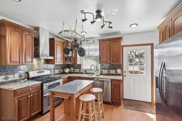 a kitchen with granite countertop cabinets a sink a window and stainless steel appliances