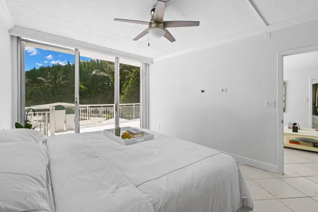 a bedroom with a bed and large window with outer view