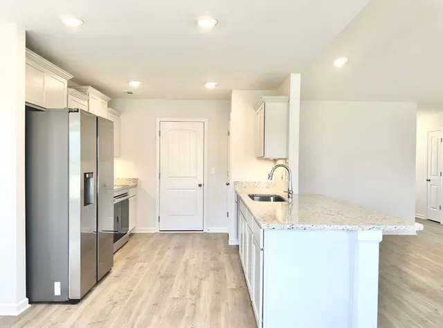 a bathroom with a granite countertop sink a mirror and shower