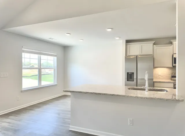 an empty room with wooden floor and window