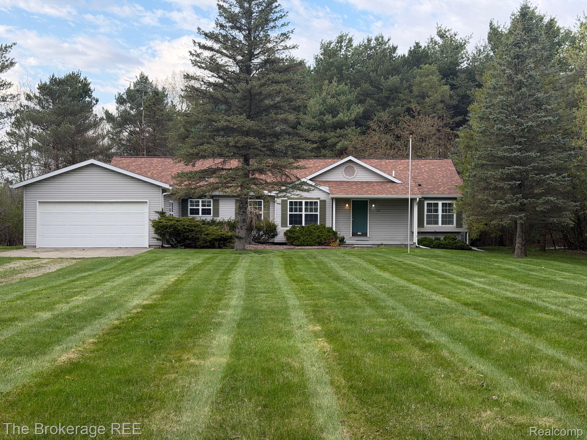 1405 E. Grand Blanc Rd. Grand Blanc, MI 48439 - Photo 1 of 1 Ranch-style home with a front yard, driveway, a porch, and an attached garage