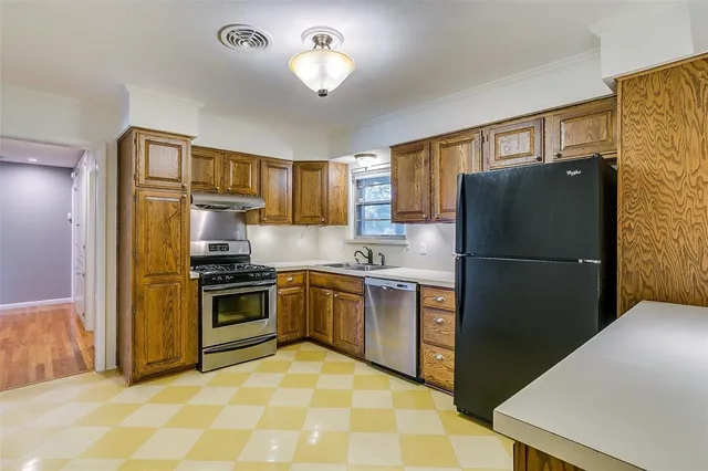 a kitchen with stainless steel appliances granite countertop a refrigerator stove and sink