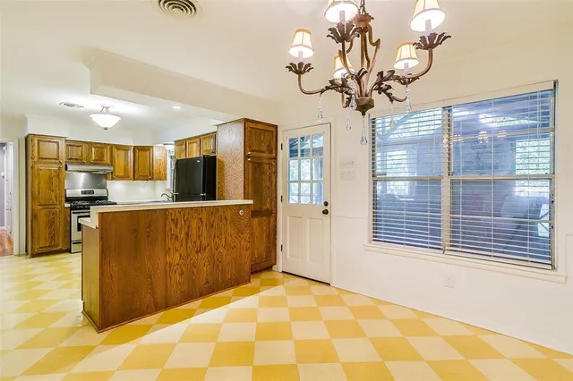 a view of a kitchen with kitchen island stainless steel appliances a chandelier