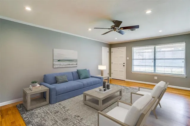 a living room with furniture a ceiling fan and a window