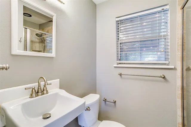 a bathroom with a sink mirror and toilet