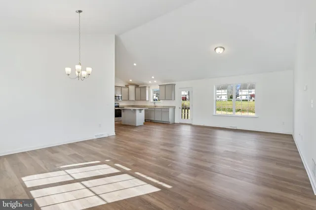 a view of a room with wooden floor and a kitchen