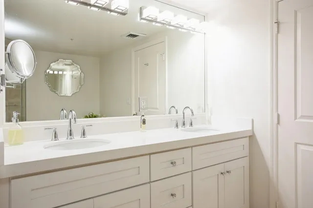 a bathroom with a double vanity sink and a mirror