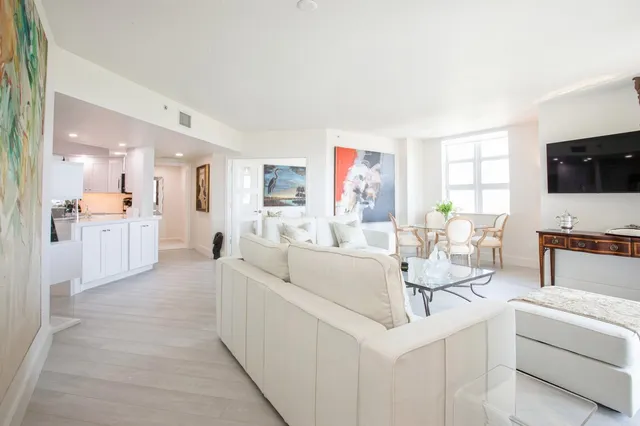 a living room with furniture a flat screen tv and a large window