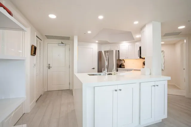 a kitchen with kitchen island a sink and a refrigerator