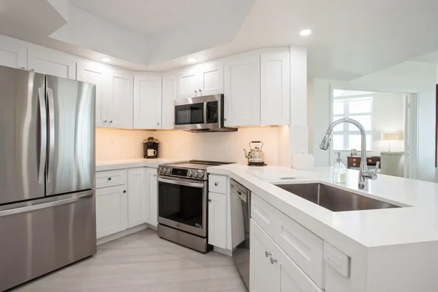 a kitchen with stainless steel appliances granite countertop a sink stove and refrigerator