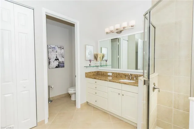 a bathroom with a granite countertop sink a mirror and a shower