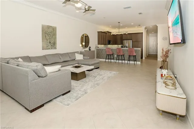 a living room with furniture and a dining table with kitchen view
