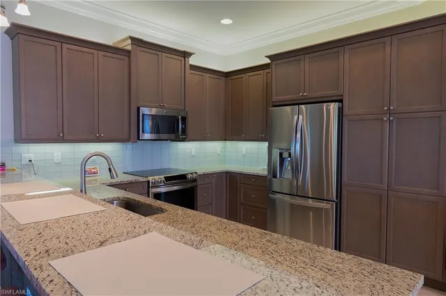 a kitchen with granite countertop a refrigerator and a sink