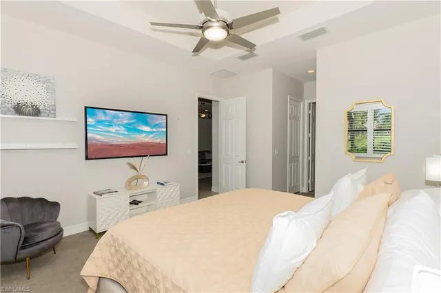 a bedroom with a bed a couch and a chandelier