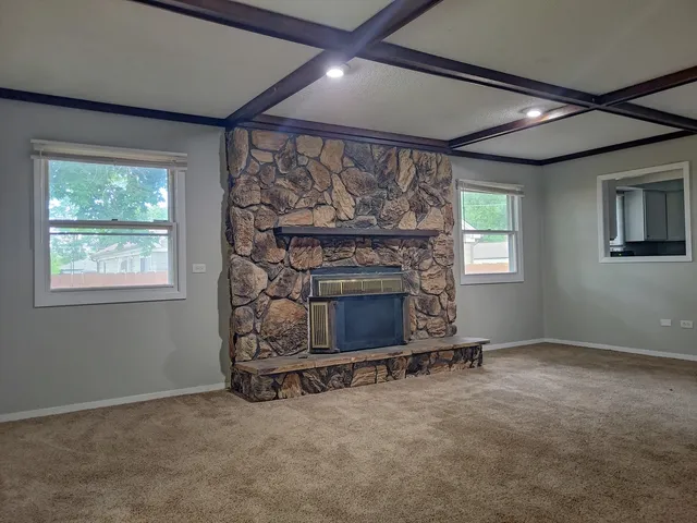 an empty room with fireplace and windows