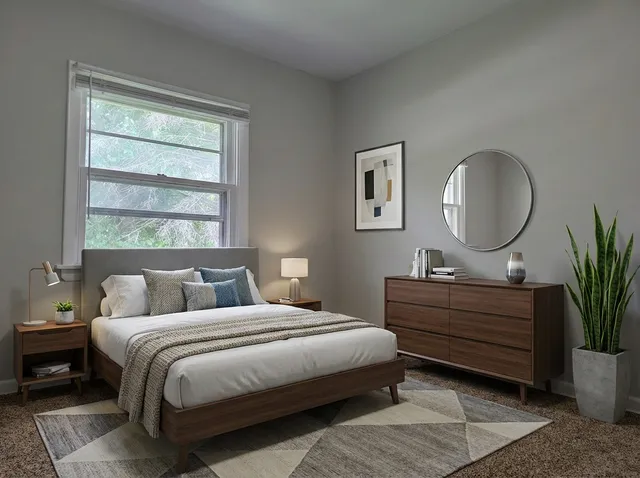 a bedroom with a bed lamp and a potted plant