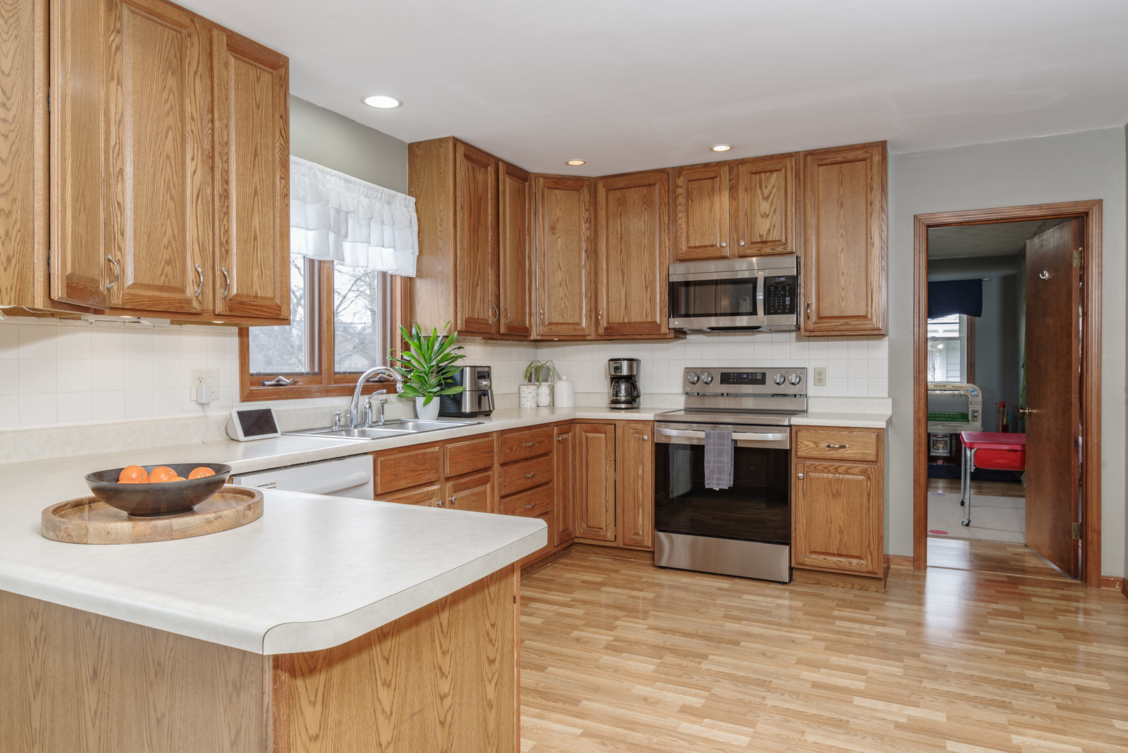 15 Robinwood Drive Normal, IL 61761 - Photo 9 of 35 a kitchen with stainless steel appliances a stove a sink a microwave and wooden cabinets