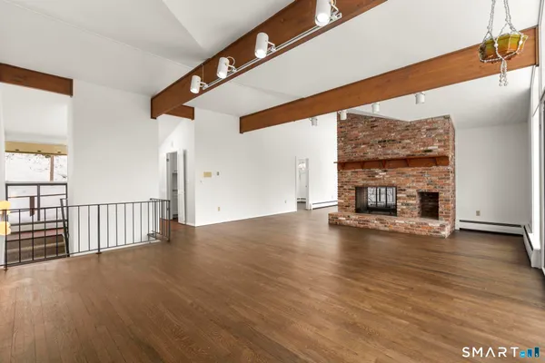 a view of empty room with wooden floor and fireplace