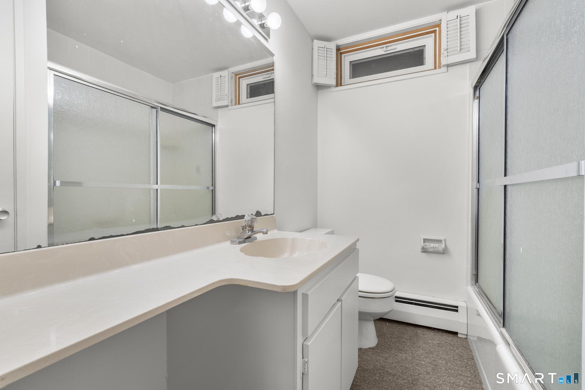 304 Olmstead Hill Road Wilton, CT 06897 - Photo 16 of 35 a bathroom with a sink a toilet and shower