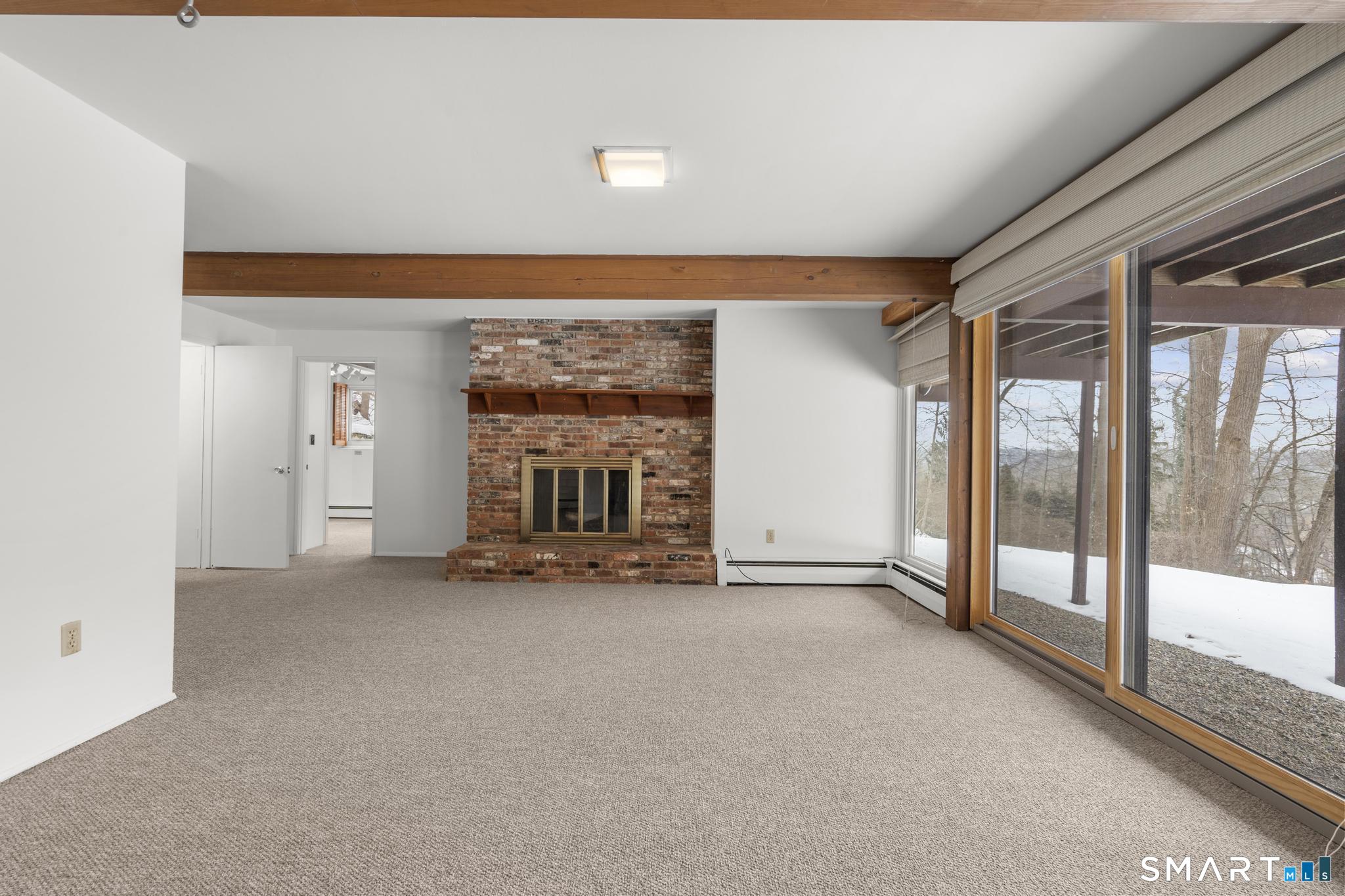 304 Olmstead Hill Road Wilton, CT 06897 - Photo 17 of 35 a view of an empty room with a fireplace and a window