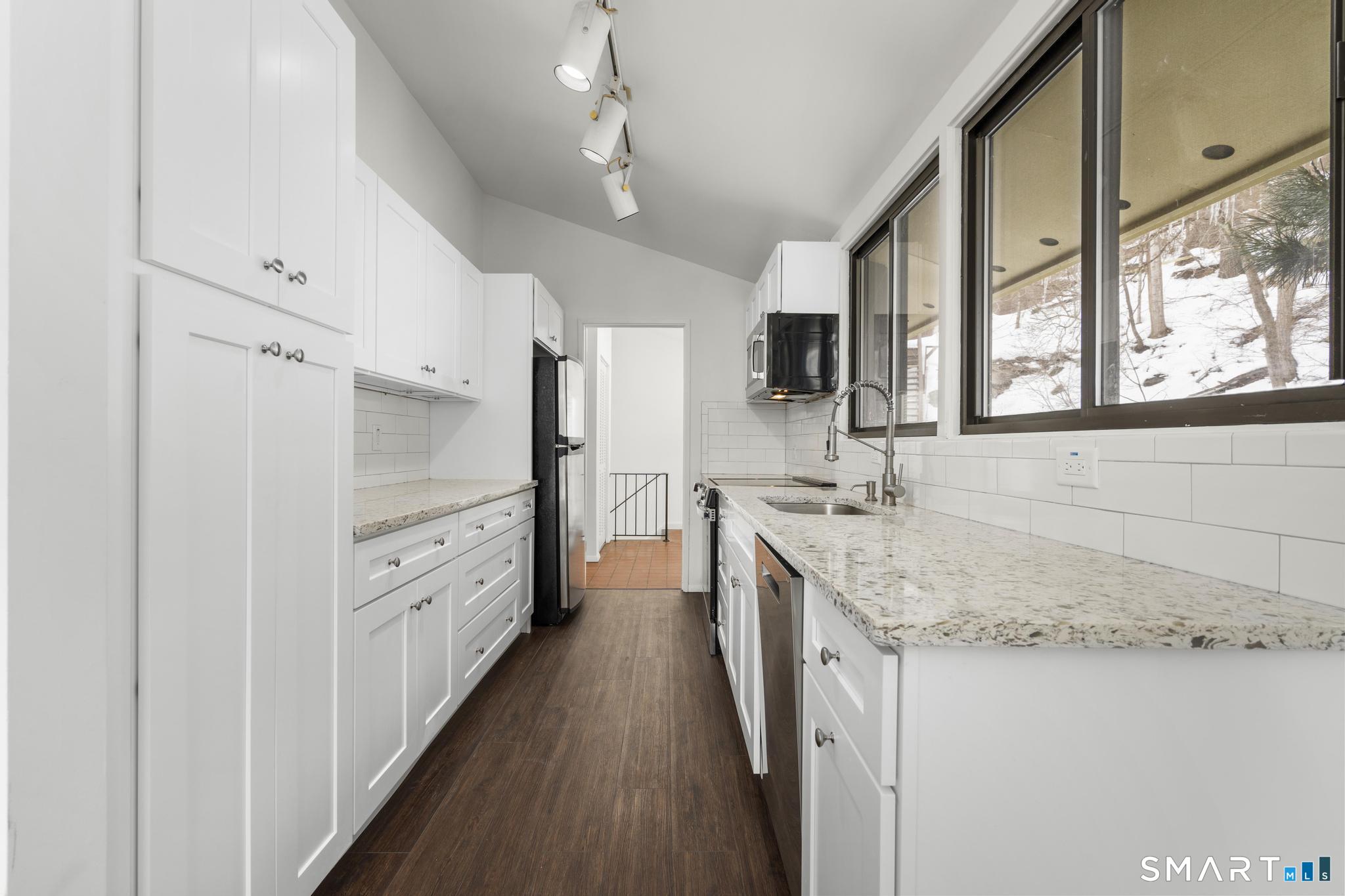 304 Olmstead Hill Road Wilton, CT 06897 - Photo 22 of 35 a large kitchen with granite countertop a sink a counter space and stainless steel appliances