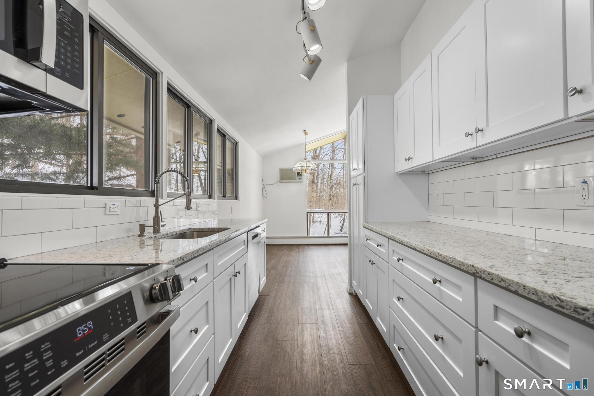 304 Olmstead Hill Road Wilton, CT 06897 - Photo 24 of 35 a kitchen with granite countertop a sink stove and cabinets