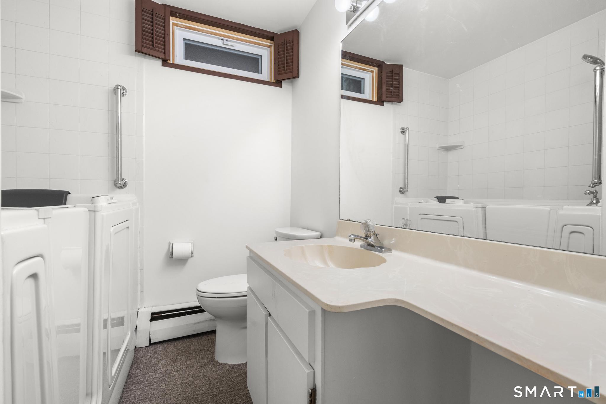 304 Olmstead Hill Road Wilton, CT 06897 - Photo 31 of 35 a bathroom with a sink and a toilet