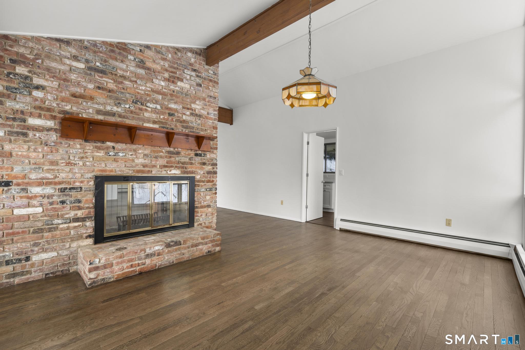 304 Olmstead Hill Road Wilton, CT 06897 - Photo 33 of 35 a view of an empty room with wooden floor and a fireplace