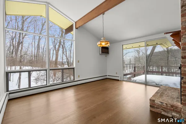 a view of an empty room and window with wooden floor
