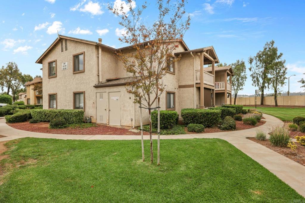 1423 Graves Avenue, Unit 238 El Cajon, CA 92021 - Photo 6 of 25 a view of a white house next to a yard with big trees