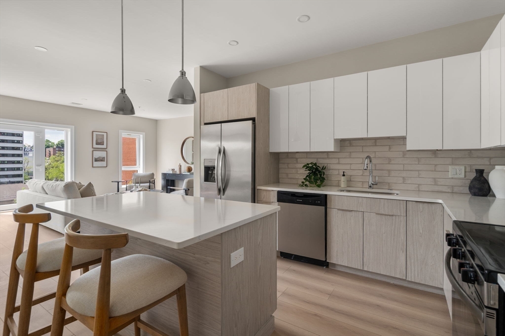 13 Wentworth Road, Unit 404 Quincy, MA 02170 - Photo 8 of 18 a kitchen with a dining table chairs sink and cabinets