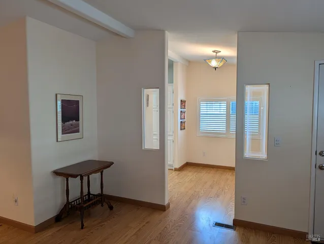 a view of a room with wooden floor and furniture