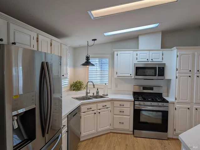 a kitchen with white cabinets and stainless steel appliances
