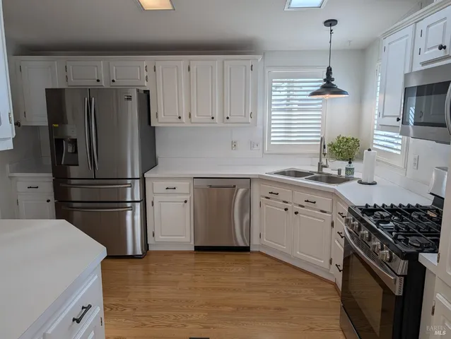 a kitchen with a sink appliances and cabinets
