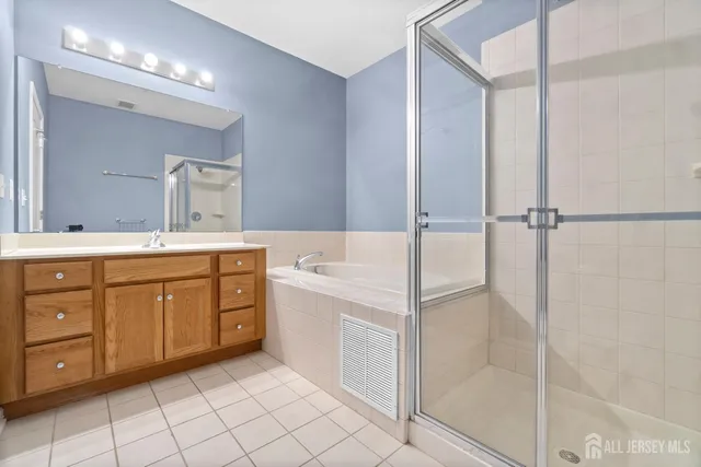 a spacious bathroom with a double vanity sink a mirror and a bathtub