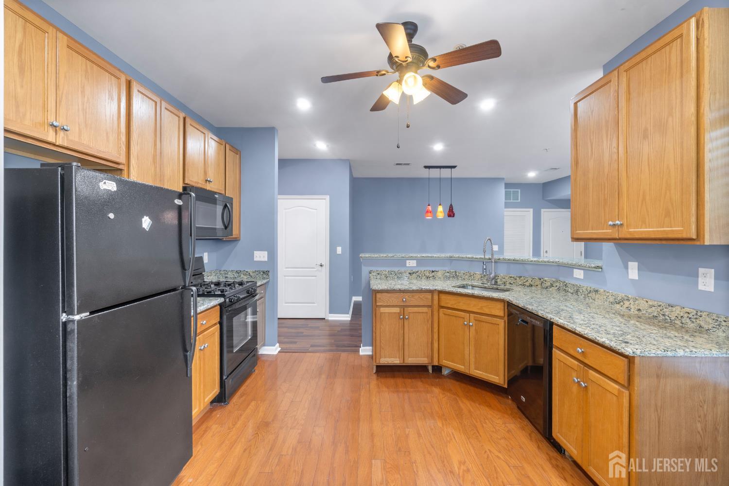 41 Azalea Drive Old Bridge, NJ 08857 - Photo 7 of 18 a kitchen with stainless steel appliances granite countertop a refrigerator a sink dishwasher a stove with wooden cabinets and floor