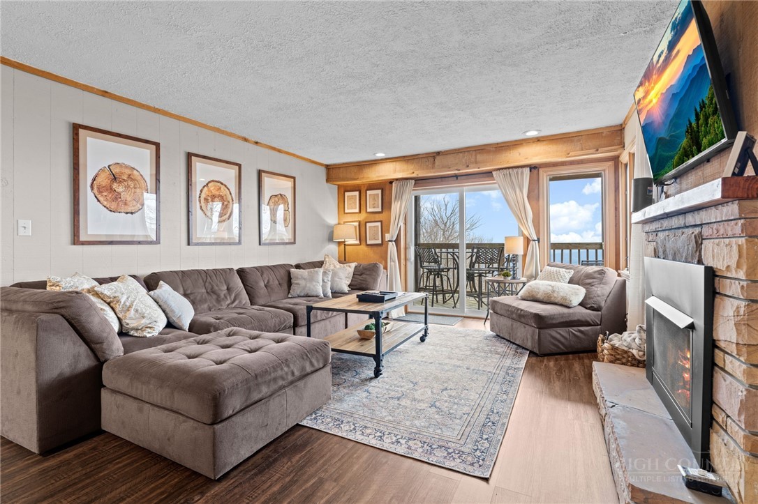220 Northridge Road, Unit 7 Beech Mountain, NC 28604 - Photo 7 of 22 a living room with furniture a flat screen tv and a floor to ceiling window