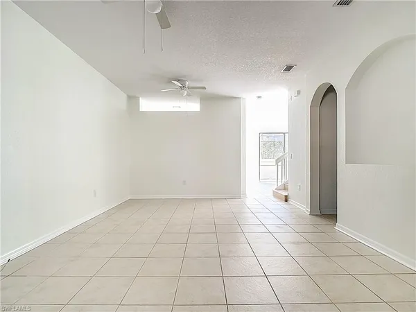 an empty room with a ceiling fan and a window