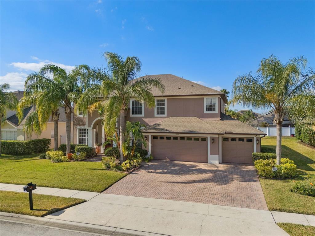 a front view of a house with a yard and potted plants