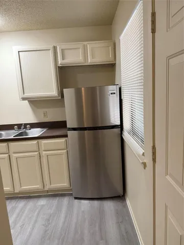 a view of a refrigerator in kitchen and wooden floor