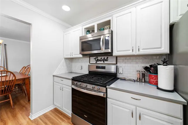 a kitchen with granite countertop a stove a sink and a microwave