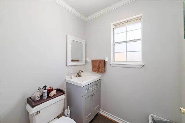 a bathroom with a sink toilet and a window