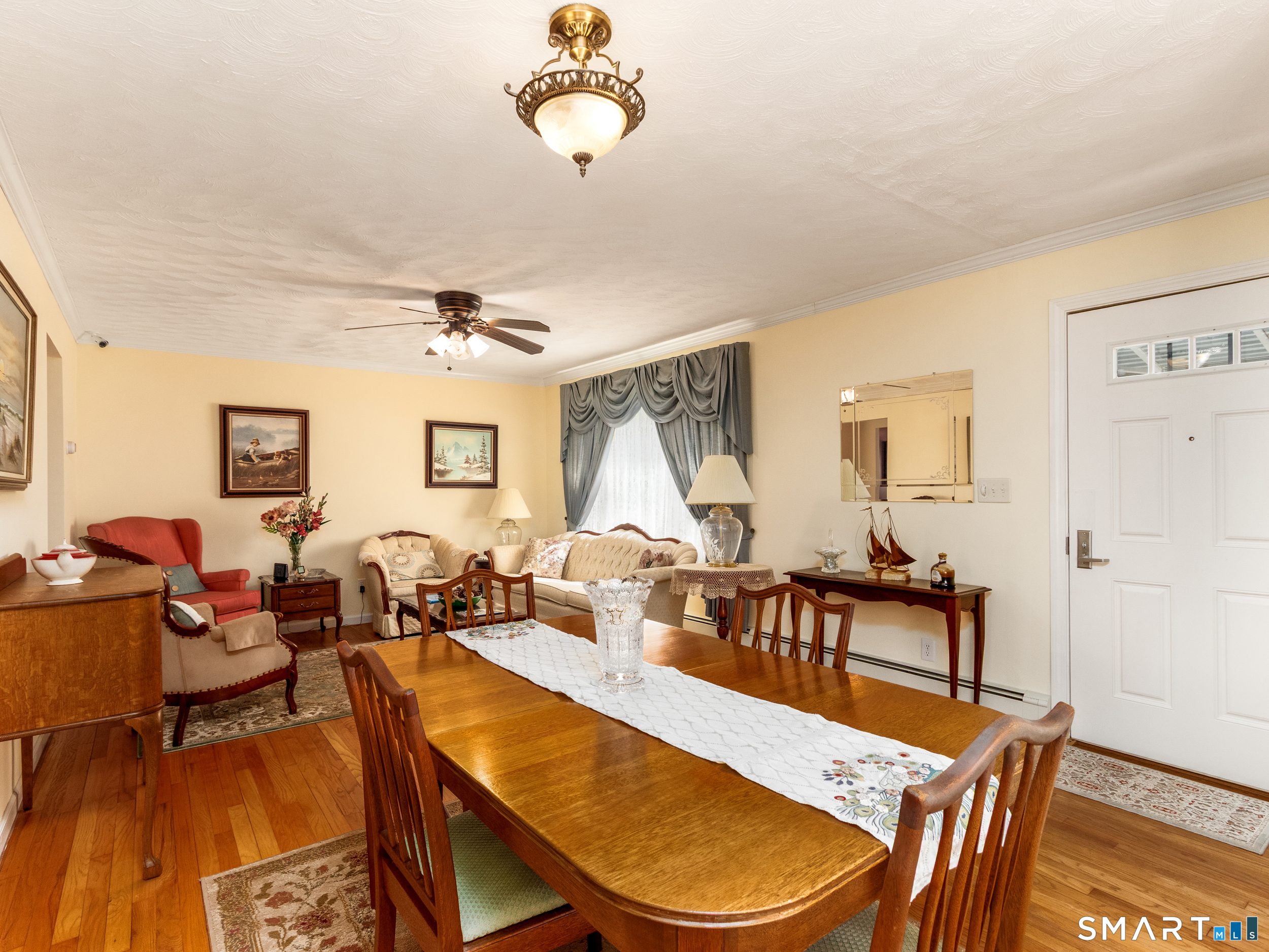 30 Lucy Street Hamden, CT 06514 - Photo 26 of 46 a dining room with wooden floor a chandelier a glass table and chairs